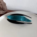 Detail of streamlined acetate hair claw clip with blue and black layered design - Teal