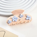 Close-up of peach acetate hair claw clip with blue flowers and crystal details - Beige Style
