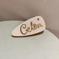 Detail der cremefarbenen Acetat-Haarspange mit goldenem Celin-Schriftzug und Strass - 5cm / Beige