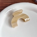 Détail de la pince à cheveux en acétate à motif marbre beige sur assiette céramique - Motif Café 5.5cm