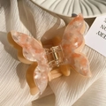 Detail of the butterfly hair claw showing orange marble texture and sturdy metal spring - Orange (6.5cm)