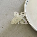 Close-up of pearlescent acetate butterfly hair claw with durable metal spring detail - Off-white