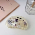Detail of a creamy white sea shell hair claw with starfish patterns and colorful rhinestones - Purple (9cm)