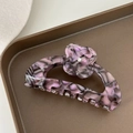 Detailopname van paarse marmeren acetaat haarklem met een klaverbloem en kleine diamantjes - Paars Marmertextuur (AMY BEAR)