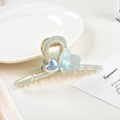 Detail of a light blue iridescent heart hair claw clip with golden metal springs - 11.5CM / Cyan