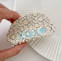 Detailed close-up of marble pattern hair claw clip with Likly heart logo held in hand - Graffiti Pebble Style