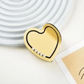 Dettaglio della clip per capelli a cuore in acetato giallo con perle e rifiniture nere - Beige