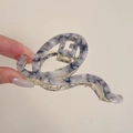 Detaillierte Makroansicht der marmorierten Acetat-Haarklammer mit goldener Metallfeder - 11cm / Beigegrau