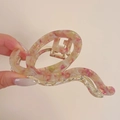 Close-up of a large pink and yellow marbled acetate hair claw clip with golden metal spring - 11cm / Sakura Pink