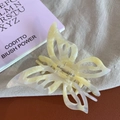 Dettaglio di una pinza per capelli a farfalla con texture marmo crema su morbido tessuto lino - Grande / Giallo