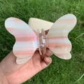 Dettaglio della clip per capelli a farfalla iridescente con trama in acetato - Rosa
