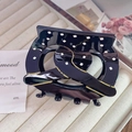 Close-up of black acetate hair claw clip with white polka dots and gold trim details - Large (8cm) / Black