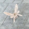 Detailed macro shot of a butterfly hair claw clip in beige resin with black patterns - Light Pink