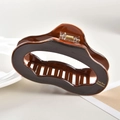 Detalle de una pinza para el pelo grande de acetato marrón oscuro con diseño ondulado - Aprox 11cm / Marrón