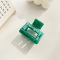 Detailed view of emerald green marbled acetic acid hair claw clip on lifestyle setting - 3.5cm / Dark Green