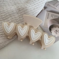 Dettaglio di un grande fermaglio per capelli crema in acetato con cuori 3D decorati - 9.6cm / Bianco avorio
