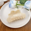 Detailed view of cream acetate hair claw with marble texture on a decorative plate - 10.5cm / Creamy White