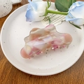 Close-up of a large marbled acetate hair claw clip with a wave-shaped edge on a porcelain tray - 10.5cm / Mixed Purple Grey