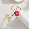 Detailed macro of gold geometric cuff bracelet with pink stone on marble stand - Rose Red Cloud Texture Style (S-B1342-G)