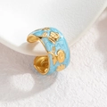 Close-up of vintage blue enamel ring with golden floral relief and polished finish - Blue