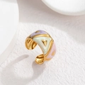 Macro shot of colorful enamel irregular striped gold open ring on white geometric background - Purple Green Pink Collage