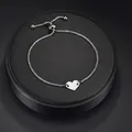 Polished silver titanium steel heart pendant bracelet with box chain on display - Silver