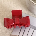 Detailed view of a bright red bow-shaped hair claw clip on a beige linen background - 4cm / Red