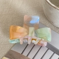 Close-up of marble pattern acetate bow hair clips in vibrant orange, green and purple colors - 4cm / Iridescent Orange