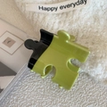 Dettaglio del fermaglio per capelli a forma di puzzle in acrilico lucido nero e verde - 5.7cm / Puzzle Verde