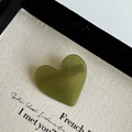 Detail of a heart-shaped leopard pattern hair clip with gold France lettering on surface - Green