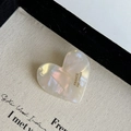 Detail view of heart-shaped cream resin hair clip with marble texture and France Handmade logo - Mermaid White