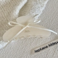Close-up of cream acetate hair claw with delicate ribbon bow and gold lettering detail - White 10cm