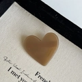 Detailed macro view of heart-shaped brown tortoiseshell hair clip with handmade engraving - Brown