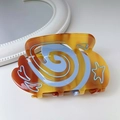 Detalle de la pinza de acetato de carey con motivos azules de estrellas y corazones - Caramelo