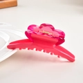 Dettaglio ravvicinato di una pinza per capelli a fiore rosa in acetato con molla in metallo - rosa acceso / 11cm