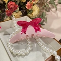 Dettaglio della pinza per capelli rosa in acetato con fiocco e design a più denti - Stile Fiocco Rosa (A696) / Rosa