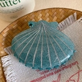 Gros plan sur la pince à cheveux coquillage sarcelle avec lignes argentées et paillettes - 8cm / Bleu