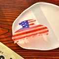 Dettaglio della pinza per capelli con bandiera americana su un piatto di ceramica bianca - Stile A