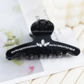 Détail d'une pince à cheveux noire brillante ornée de motifs floraux en strass étincelants - 8.8cm / Noir