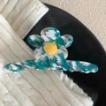 Détail macro d'une pince à cheveux fleur en acétate avec marbrure verte blanche et cœur jaune - Vert