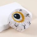 Close-up of marble acetate hair claw clip featuring a unique evil eye design and lashes - Type B Yellow Eyeball