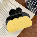 Dettaglio di una pinza per capelli a forma di budino su un libro vintage - Fermaglio a Pinza Budino (7cm)