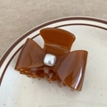 Close-up of caramel brown acetate hair claw clip with a square white pearl bow detail - 6cm / Caramel color