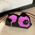 Détail d'une pince à cheveux panda géométrique noire et violette sur un plateau - Violet