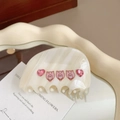 Detalle de pinza para el pelo crema marmoleada con cerditos rosas y pedrería - Patrón de Cerdo / crema
