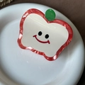 Detail view of apple-shaped acetate hair claw clip with a cute smiley face and leaf - Red Apple 6.8cm