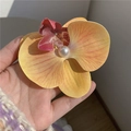Détail d'une pince à cheveux orchidée jaune avec texture de pétale réaliste et perle - Orange