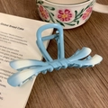 Detail view of a light blue gradient ribbon hair claw clip on an aesthetic wooden desk - Gradient Blue 11cm