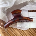 Close-up of a large tortoiseshell hair claw clip with a glossy curved acetate finish - 11.5x4.5cm / Matte Tortoiseshell