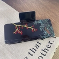 Detalle de pinza para el pelo de acetato negro con ramas doradas y diamantes rojos - Pinza Rectangular Negra Grande
